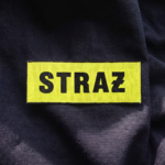 Napis STRAŻ 5 × 15 cm na ciemnej odzieży koszarowej